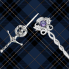 Close-up shot showcasing a beautifully crafted kilt pin securely fastened on a vibrant tartan kilt. The intricate details of the pin add elegance and style to the traditional Scottish attire.