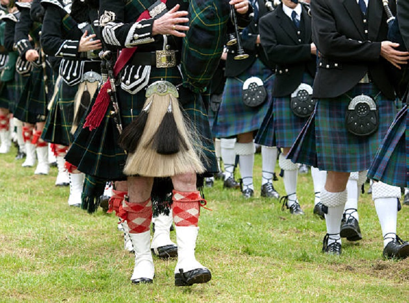 men marching wearing different kilt.