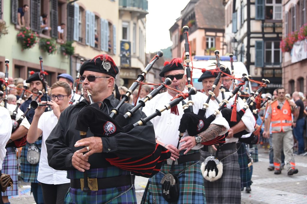 men with bagpipe representing kilt as a global world people charming